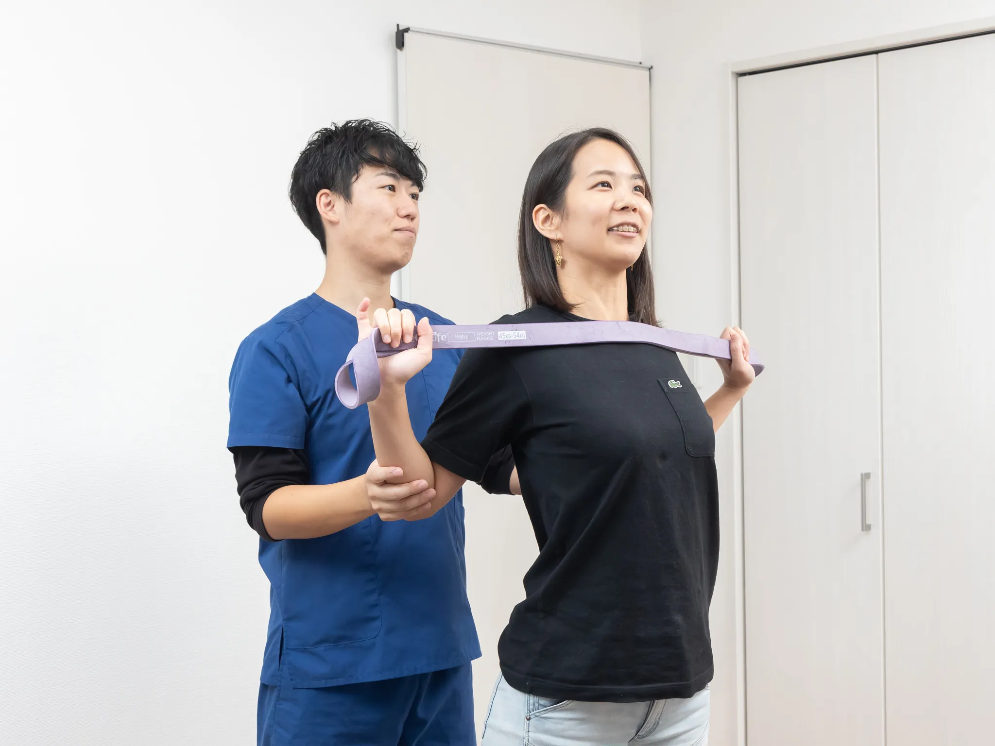 施術者が、立って体を動かす方の動きを確かめている様子